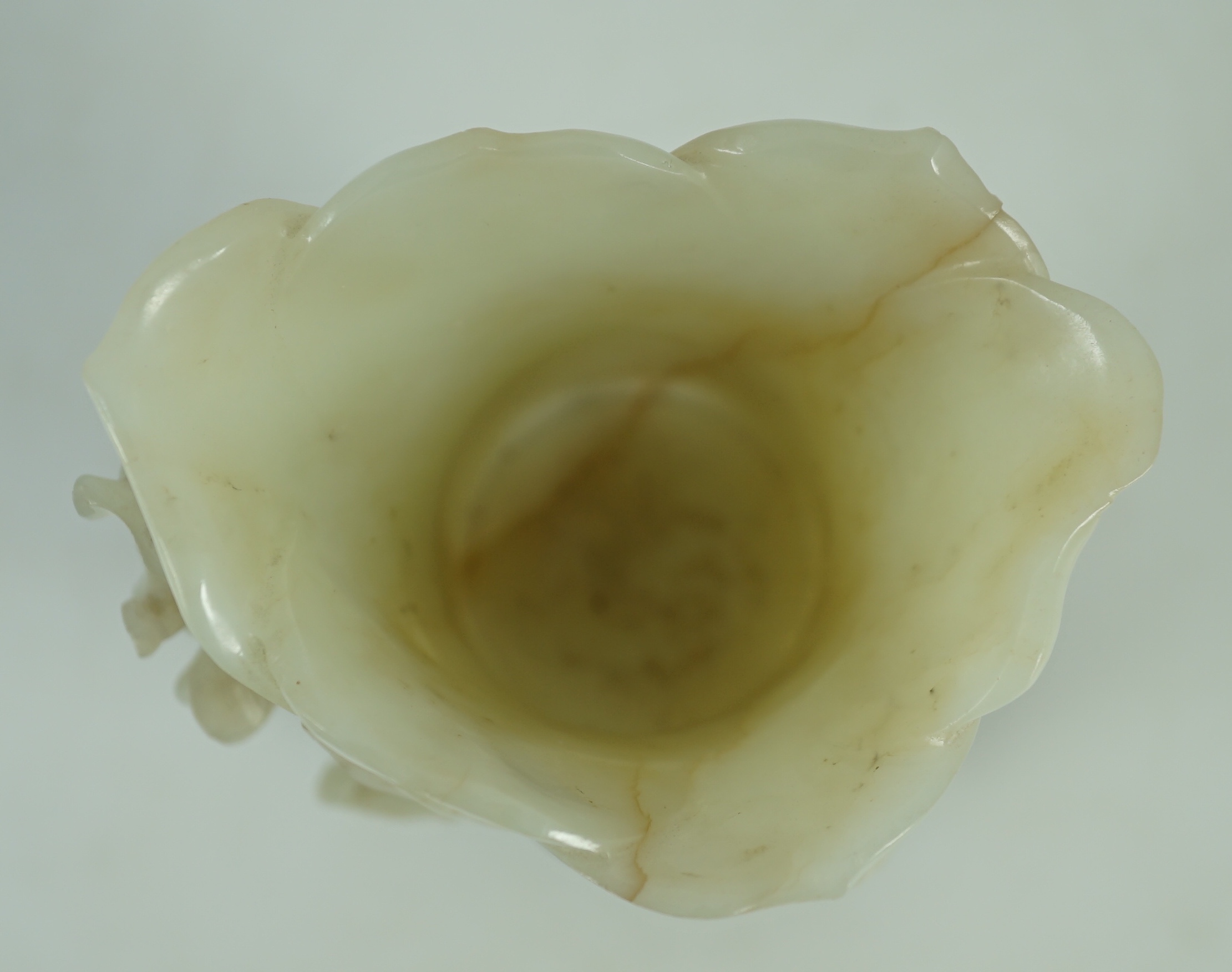 A large Chinese pale celadon jade ‘magnolia’ cup, 17th/18th century 17.5cm high excluding wood stand